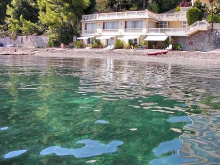 Villa sur la plage, pieds dans l'eau.