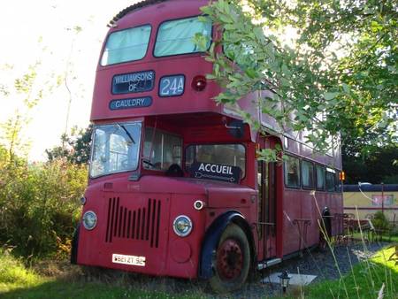 Un bus impérial et une roulotte ancienne dans un parc naturel de 10 hectares.